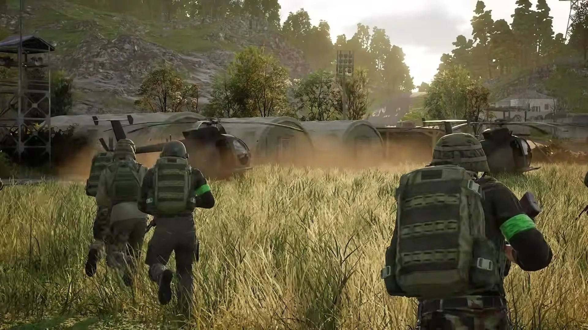 Three WARDOGS operators moving through tall grass toward the objective