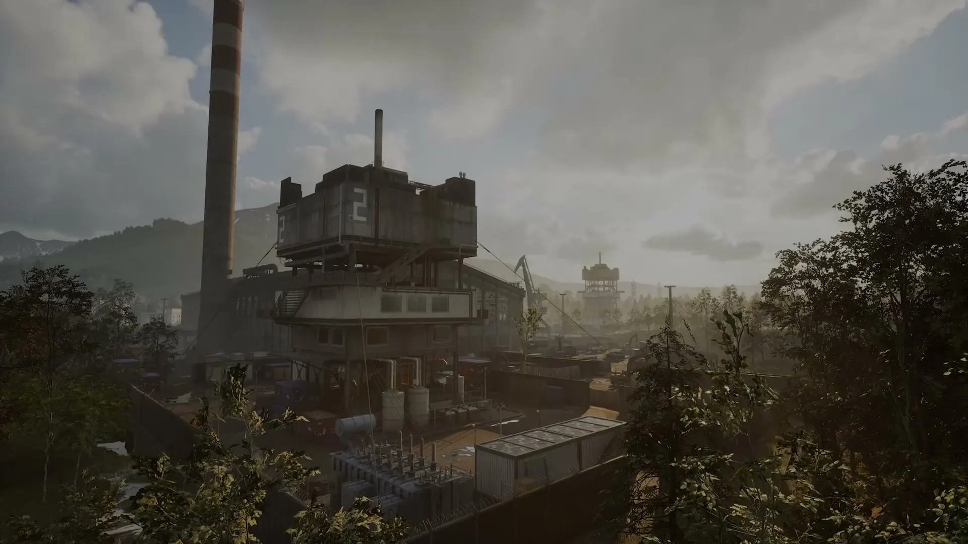 An industrial WARDOGS compound beneath a gray mountain skyline